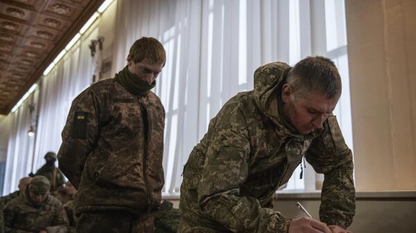 A Ukrainian soldier who voluntarily laid down his arms signs an agreement not to participate in hostilities. Lugansk, 25 February 2022. - Sputnik International