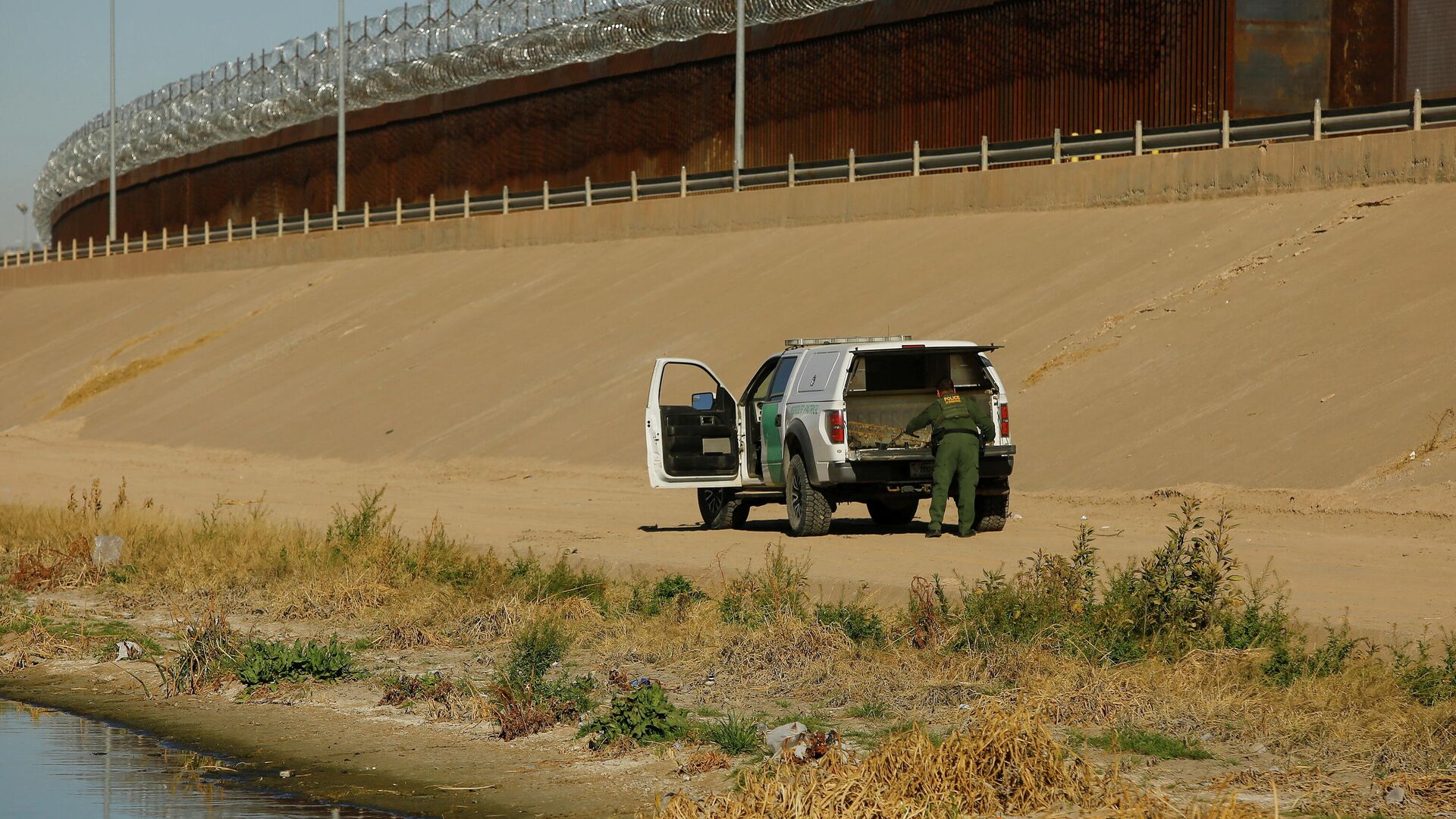 A U.S. Border Patrol agent removes a device commonly used as a ladder near the border wall during a mirror patrol, which simultaneously deploys Mexican police officers and U.S. Border Patrol agents along their respective sides of the border in response to an increased migrant influx in past days, as seen from Ciudad Juarez, Mexico, February 26, 2022.  - Sputnik International, 1920, 01.03.2022