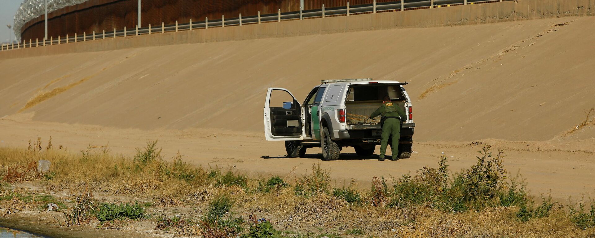 A U.S. Border Patrol agent removes a device commonly used as a ladder near the border wall during a mirror patrol, which simultaneously deploys Mexican police officers and U.S. Border Patrol agents along their respective sides of the border in response to an increased migrant influx in past days, as seen from Ciudad Juarez, Mexico, February 26, 2022.  - Sputnik International, 1920, 01.03.2022