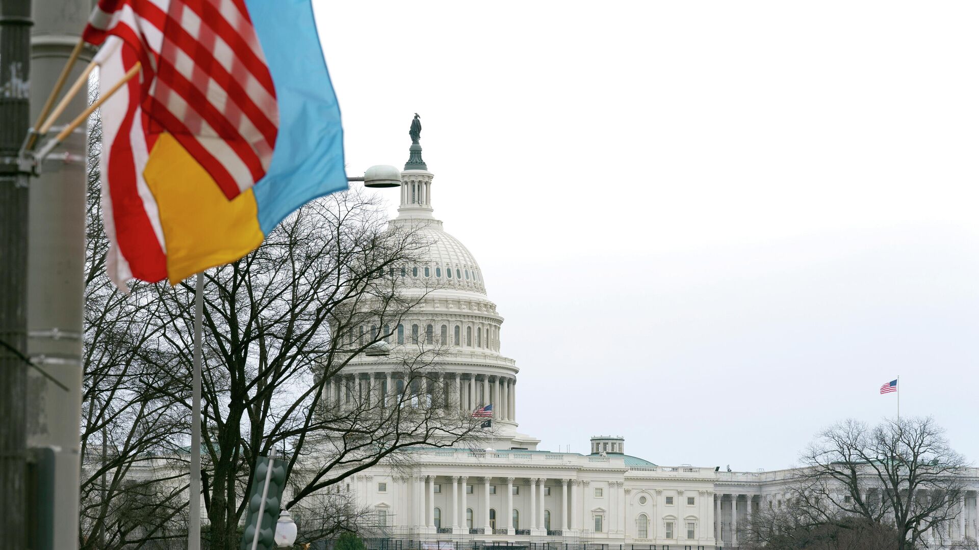 The U.S. Capitol is seen behind the U.S. flag, Ukrainian flag and the flag of Washington, D.C., in Washington, Tuesday, March, 1, 2022. President Joe Biden will deliver his first State of the Union address at a precipitous moment for the nation. Biden is aiming to navigate the country out of a pandemic, reboot his stalled domestic agenda and confront Russia’s aggression. - Sputnik International, 1920, 01.03.2022