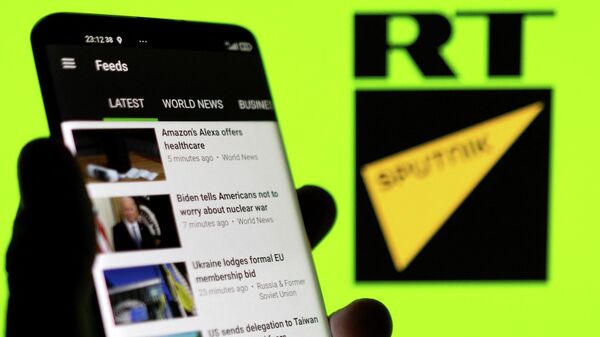 RT app is seen on a smartphone in front of RT and Sputnik logo in this illustration taken February 28, 2022 - Sputnik International