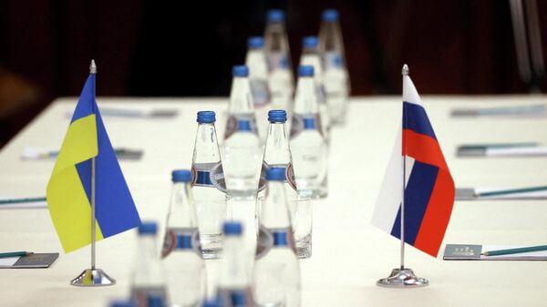 Russian and Ukrainian flags are seen on a table before the talks between officials of the two countries in the Gomel region, Belarus February 28, 2022 - Sputnik International