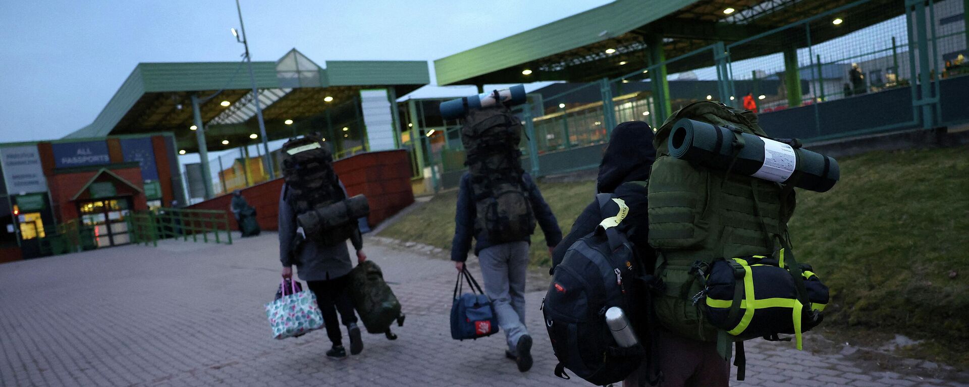 Ukrainian men carry their equipment towards the border as they return to Ukraine to fight the Russian forces, at the border checkpoint in Medyka, Poland, March 2, 2022 - Sputnik International, 1920, 03.03.2022