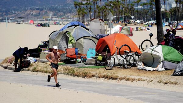  In this June 8, 2021, file photo, a jogger runs past a homeless encampment in the Venice Beach section of Los Angeles. - Sputnik International