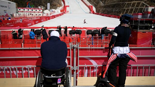 A paralympic athlete crosses the finish line during a training session for the men's downhill sitting event at the Yanqing National Alpine Skiing Centre in Yanqing ahead of the Beijing 2022 Winter Paralympic Games on March 3, 2022. - Sputnik International