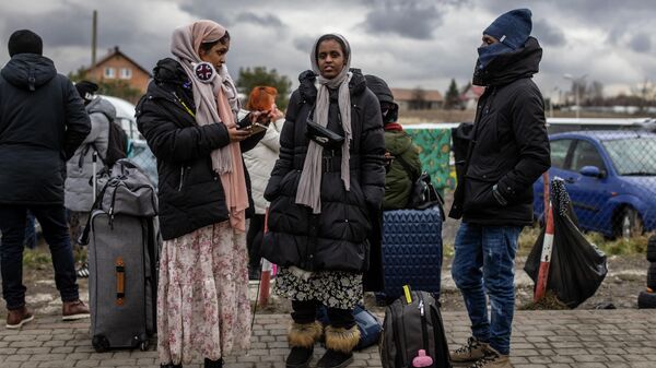 Indian girls wait for transport as refugees from many diffrent countries - from Africa, Middle East and India - mostly students of Ukrainian universities arrive at the Medyka pedestrian border crossing fleeing the conflict in Ukraine, in eastern Poland on February 27, 2022 - Sputnik International