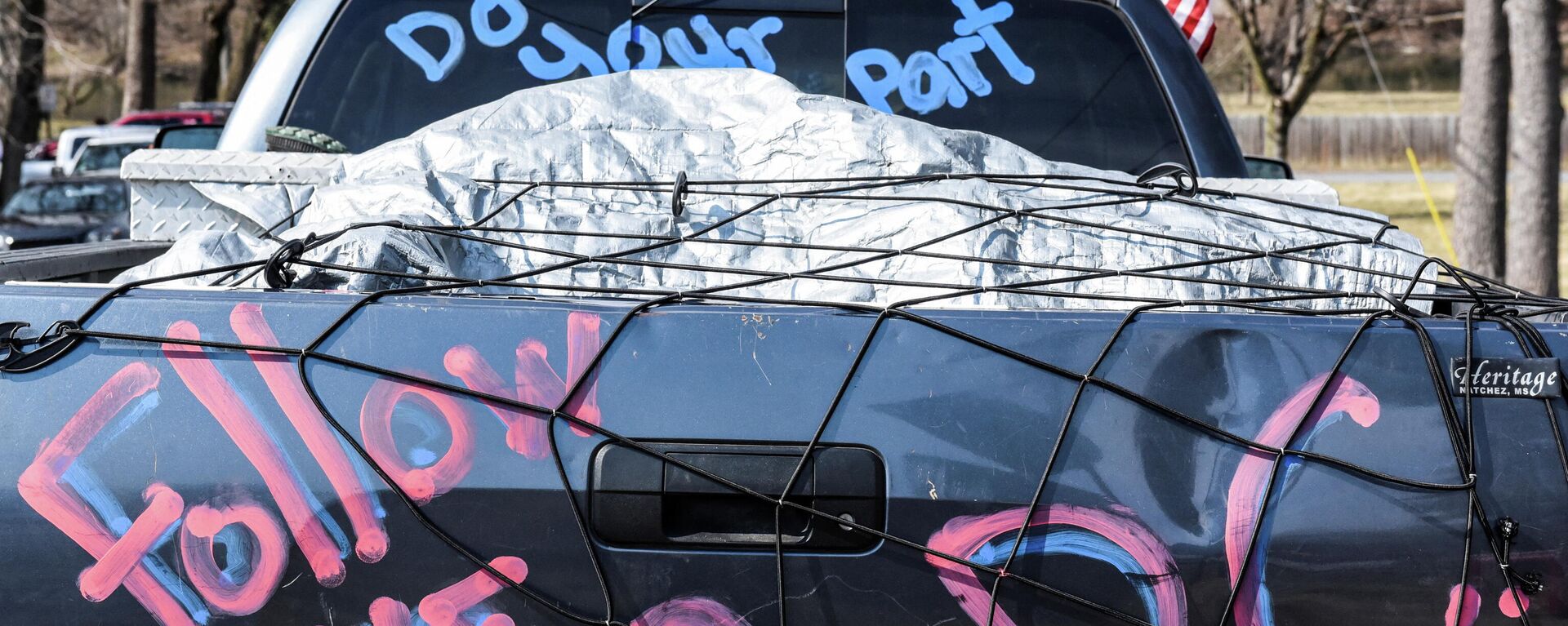 A written message reading follow me to D.C. is seen on the back of a truck as hundreds of vehicles including 18-wheeler trucks, RVs and other cars are parked as part of a rally at Hagerstown Speedway after some of them arrived as part of a convoy that travelled across the country headed to Washington D.C. to protest coronavirus disease (COVID-19) related mandates and other issues in Hagerstown, Maryland, U.S., March 5, 2022. - Sputnik International, 1920, 14.03.2022