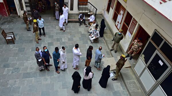 Voters stand in a queue to cast their ballot at a polling station during the final phase of the Uttar Pradesh state assembly elections, in Varanasi on March 7, 2022.  - Sputnik International
