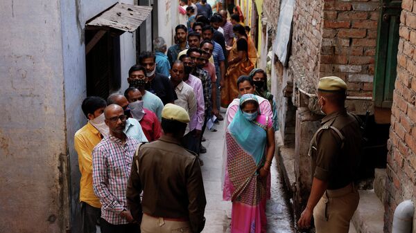 People stand in a queue to cast their votes at a polling station during the last phase of state assembly election in Varanasi in the northern state of Uttar Pradesh, India, March 7, 2022 - Sputnik International