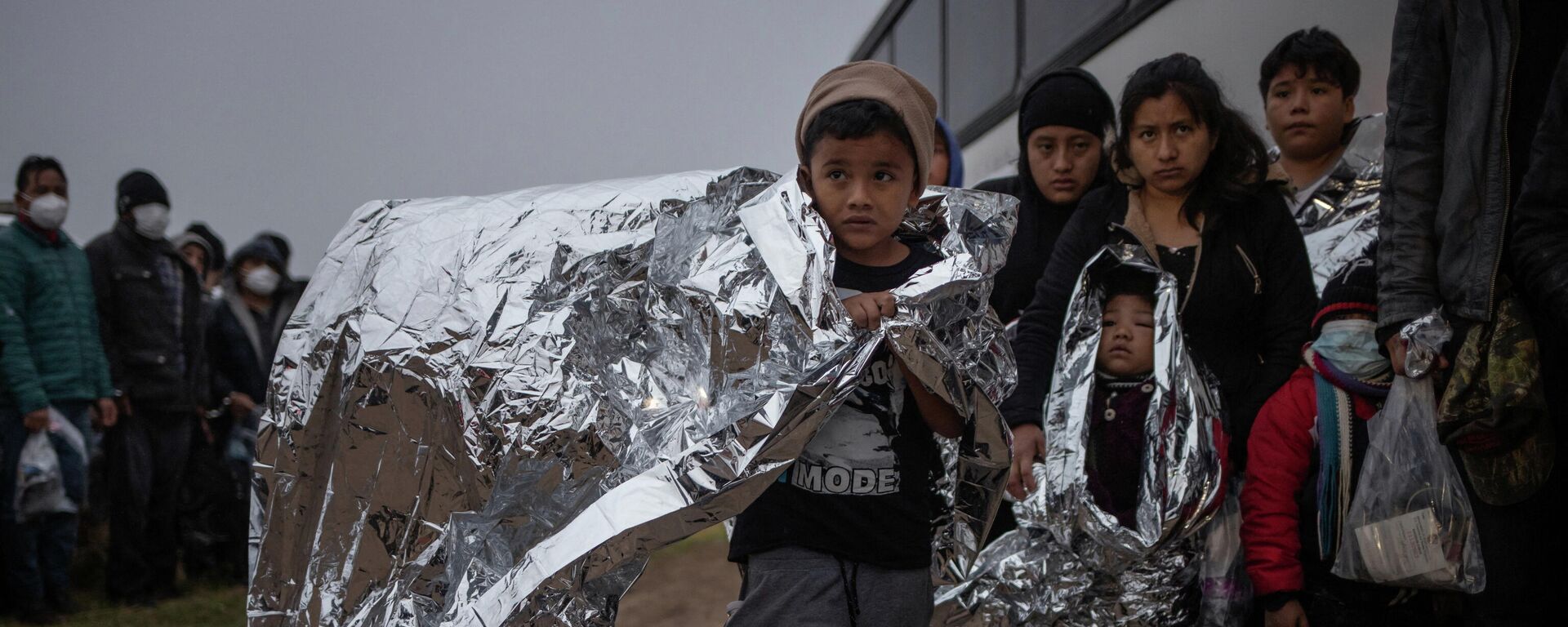 Issac, a seven year old unaccompanied migrant boy from Honduras, holds an emergency blanket as he is asked by a Customs and Border Protection official to board a bus after crossing the Rio Grande river into the United States from Mexico in Penitas, Texas, U.S., February 24, 2022 - Sputnik International, 1920, 12.03.2022
