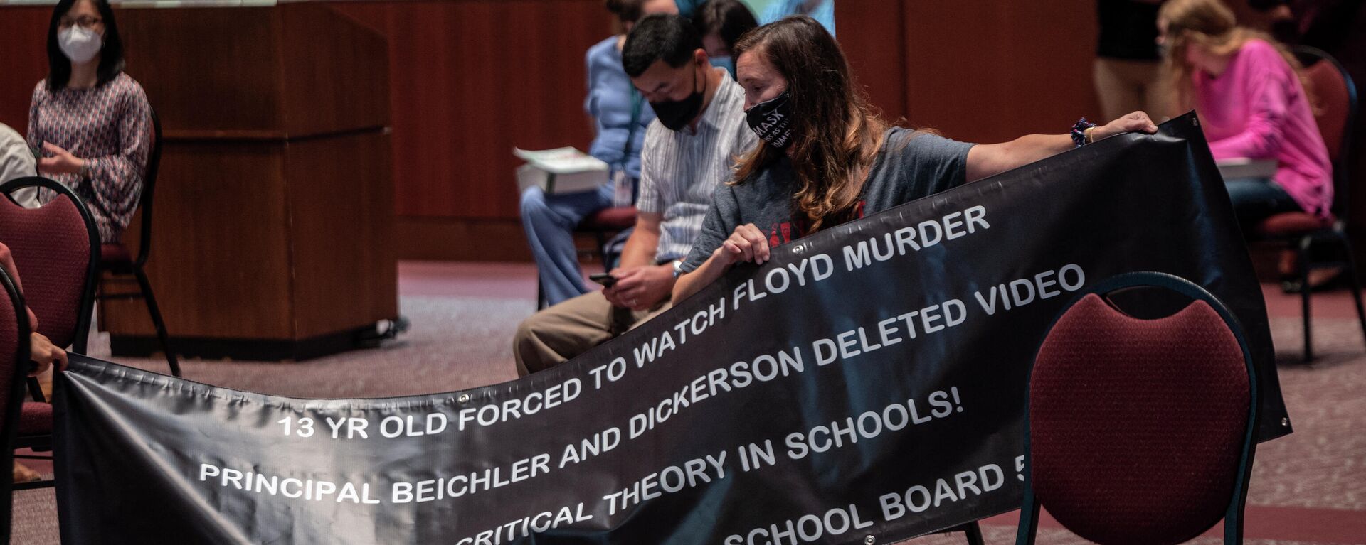 A woman holds up her sign against Critical Race Theory (CRT) being taught during a Loudoun County Public Schools (LCPS) board meeting in Ashburn, Virginia on October 12, 2021 - Sputnik International, 1920, 13.03.2022