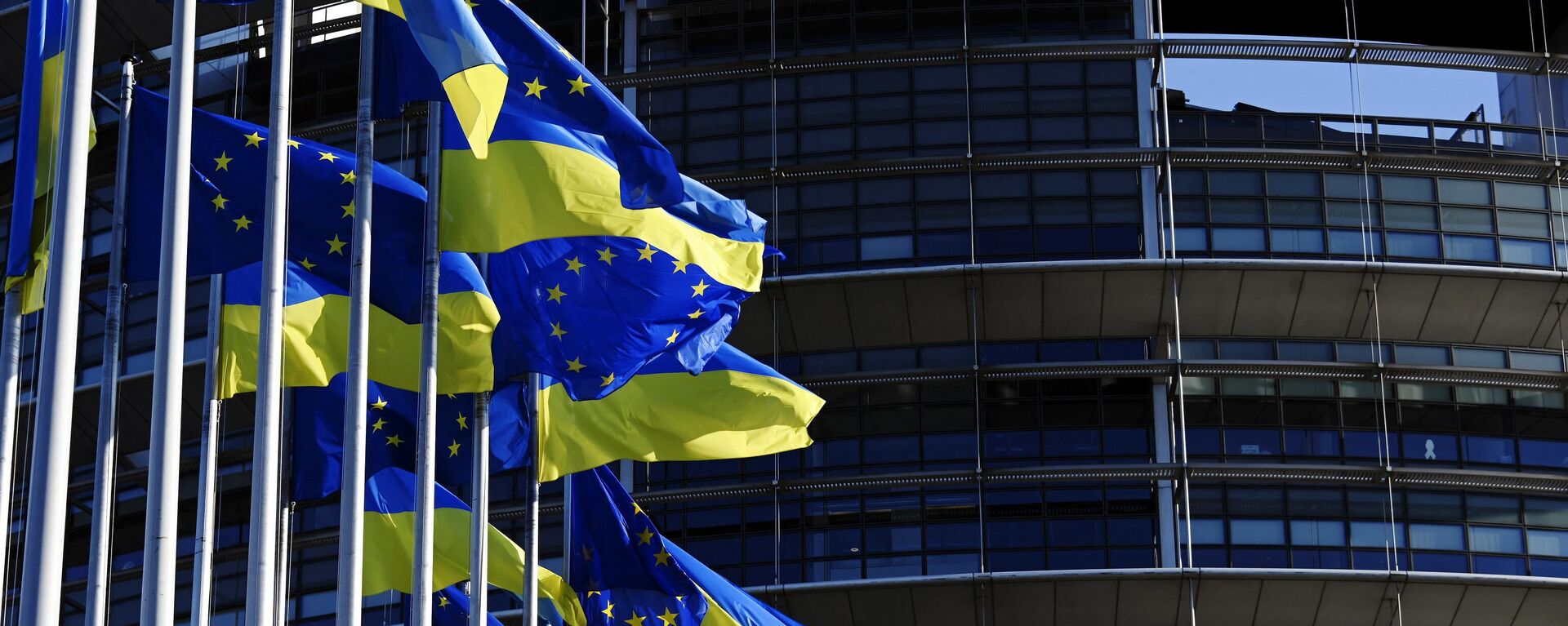 A picture taken on March 8, 2022 shows European Union's and Ukrainian flags fluttering outside the European Parliament in Strasbourg, eastern France. - Sputnik International, 1920, 13.03.2022