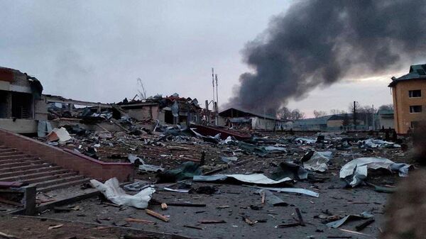 Smoke rises amid damaged buildings following an attack on the Yavorov military base, in Yavorov, Lvov Oblast, Ukraine, March 13, 2022 in this picture obtained from social media. @BackAndAlive/via REUTERS  THIS IMAGE HAS BEEN SUPPLIED BY A THIRD PARTY. MANDATORY CREDIT. NO RESALES. NO ARCHIVES. - Sputnik International