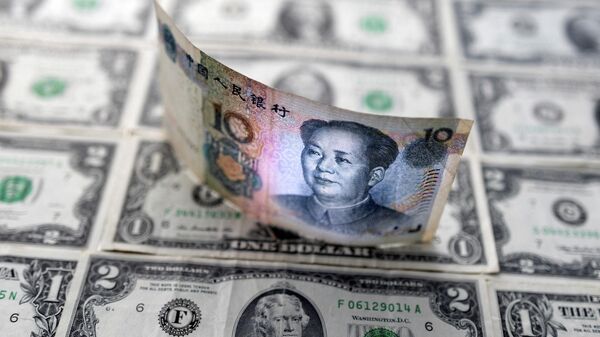 Chinese yuan banknote is displayed on U.S. Dollar banknotes in this illustration taken, February 14, 2022. REUTERS/Dado Ruvic/Illustration - Sputnik International