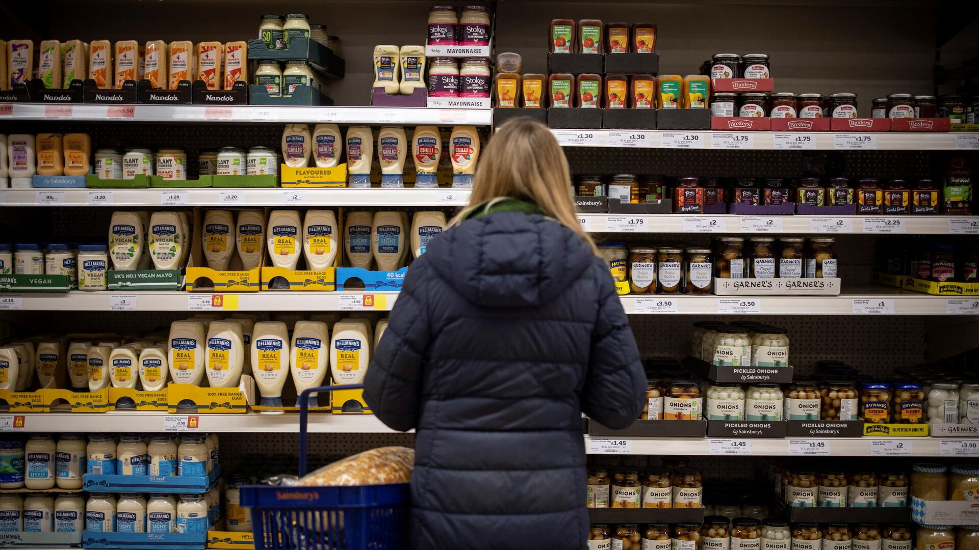 A customer shops for mayonnaise and condiments at a Sainsbury's supermarket in Walthamstow, east London on February 13, 2022 - Sputnik International, 1920, 24.03.2022