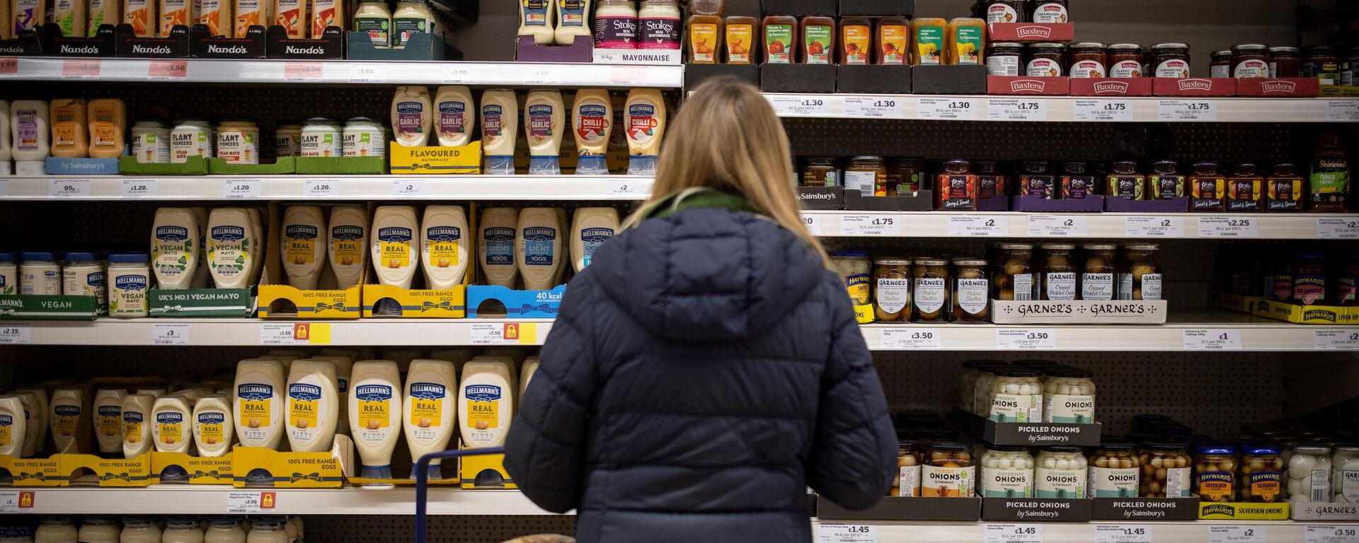 A customer shops for mayonnaise and condiments at a Sainsbury's supermarket in Walthamstow, east London on February 13, 2022 - Sputnik International, 1920, 14.03.2022