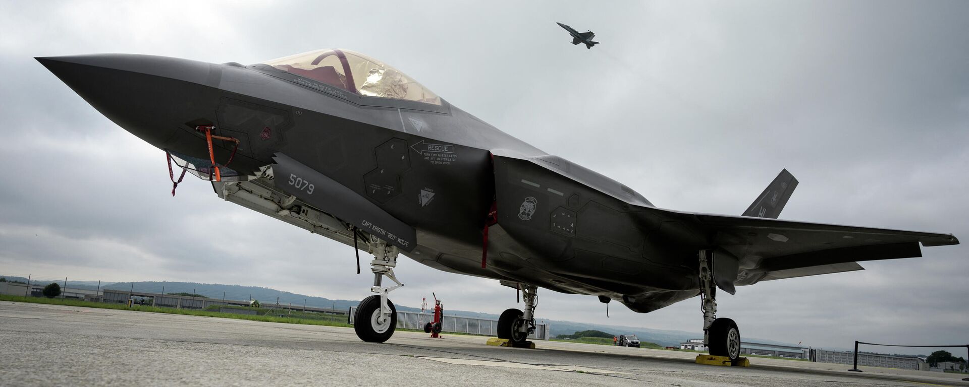 This file photo taken on June 7, 2019 shows a Lockheed Martin F-35 Lightning II fighter jet parked on the tarmac at the Payerne Air Base as a Boeing McDonnell Douglas F/A-18 Hornet takes off in the background, during flight and ground tests. - Sputnik International, 1920, 14.03.2022
