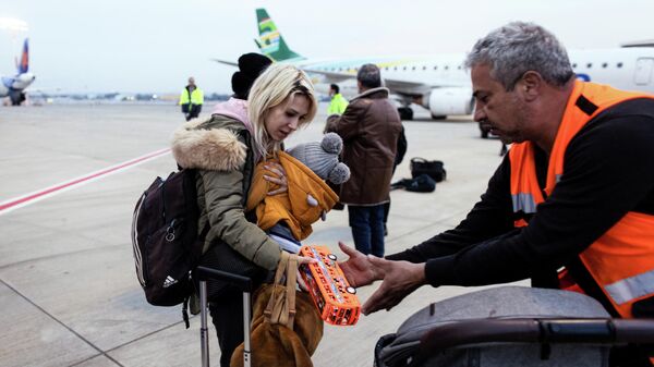 An Israeli man helps a Ukranian refugee as she arrives from Romania after Russia's invasion of Ukraine, at Ben Gurion international airport in Lod near Tel Aviv, Israel, March 8, 2022 - Sputnik International