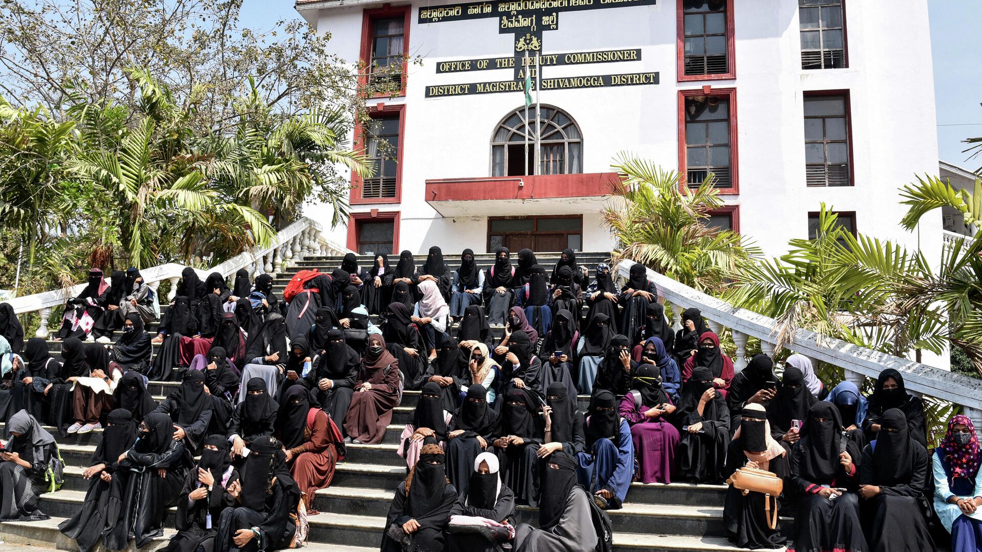 Students and supporters sit in front of the office of the deputy commissioner as a sign of protest in Shivamogga district in India’s Karnataka state on February 17, 2022, a day after educational institutions reopened in southern India under tight security after authorities banned public gatherings following protests over Muslim girls wearing the hijab in classrooms.  - Sputnik International, 1920, 15.03.2022