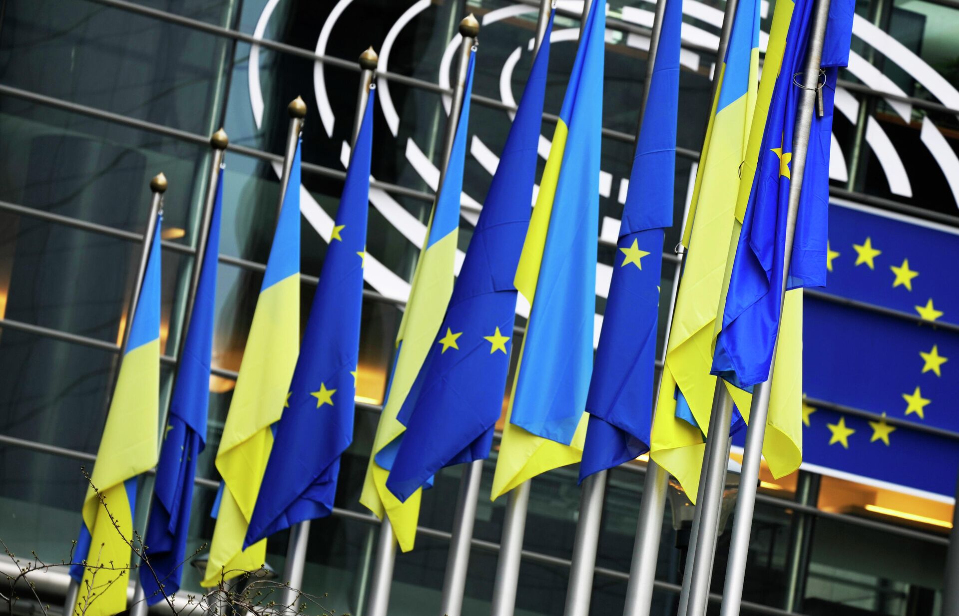 Ukraine and European Union flags hang together on the exterior of the building prior to an extraordinary plenary session on Ukraine at the European Parliament in Brussels, Tuesday, March 1, 2022 - Sputnik International, 1920, 24.03.2022