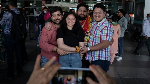 An Indian student who was evacuated from Ukraine stands for a photograph with his family upon arrival at the Indira Gandhi International Airport in New Delhi, India, Friday, March 11, 2022 - Sputnik International