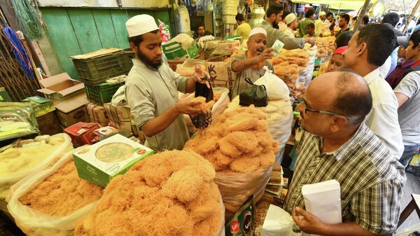 An Indian Muslim vendor sells 'sewai' and dry food ahead of the Eid al-Fitr holiday which marks the end of the holy month of Ramadan, at Fancy Bazar in Guwahati on June 14, 2018 - Sputnik International