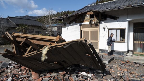 Sushi maker Akio Hanzawa walks in front of his damaged restaurant in Shiroishi, Miyagi prefecture on March 17, 2022, after a 7.3-magnitude earthquake jolted east Japan the night before.  - Sputnik International