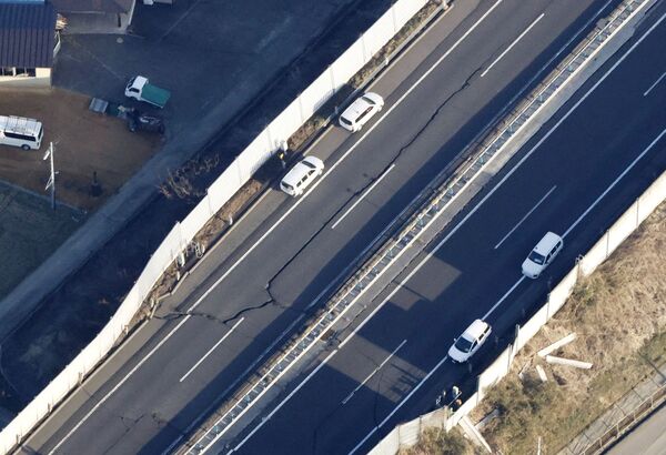 Трещины на дороге после сильного землетрясения в Сироиси, Япония - Sputnik International