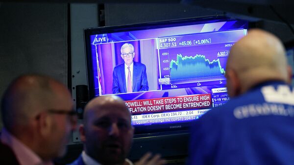 Traders work, as Federal Reserve Chair Jerome Powell is seen on a screen delivering remarks, at the New York Stock Exchange (NYSE) in New York City, U.S., March 16, 2022. - Sputnik International