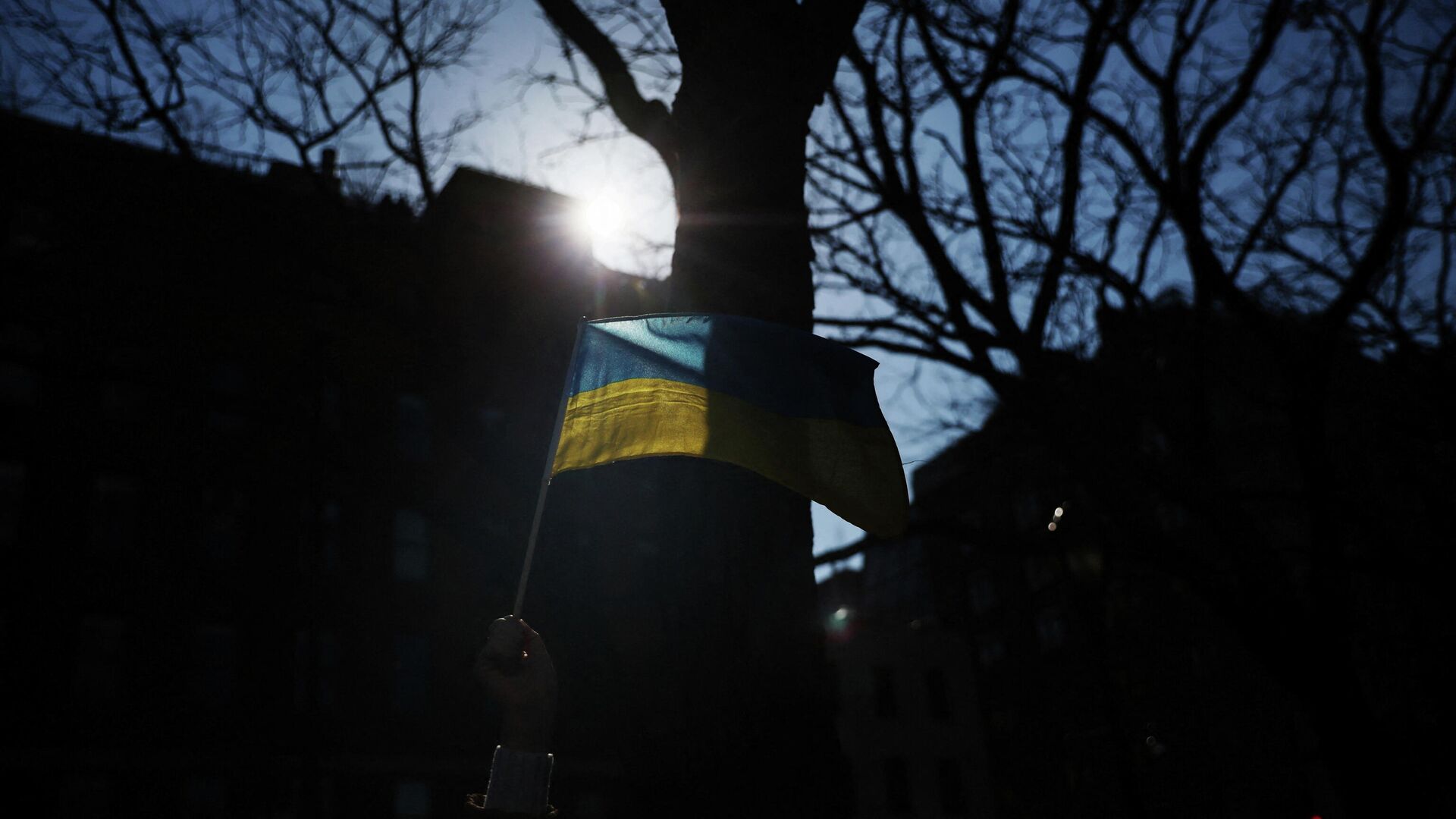 A demonstrator holds a flag of Ukraine outside a Citibank location during an anti-war rally in New York City, U.S., March 16, 2022 - Sputnik International, 1920, 20.03.2022