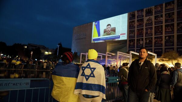 People gather in Habima Square in Tel Aviv, Israel, to watch Ukrainian President Volodymyr Zelensky  in a video address to the Knesset, Israel's parliament, Sunday, March 20, 2022 - Sputnik International