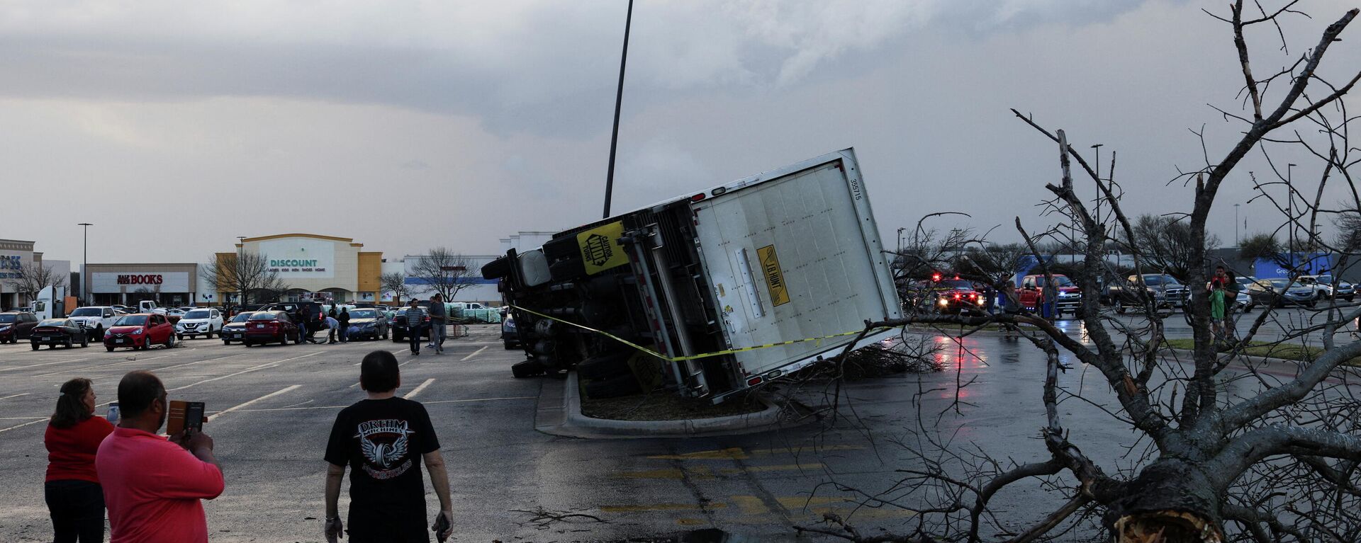 People look at an overturned truck in a parking lot after a tornado in a widespread storm system touched down in Round Rock, Texas, U.S., March 21, 2022 - Sputnik International, 1920, 22.03.2022