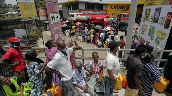 People stand in a long queue to buy kerosene oil for kerosene cookers amid a shortage of domestic gas due to country's economic crisis, at a fuel station in Colombo, Sri Lanka March 21, 2022.  - Sputnik International