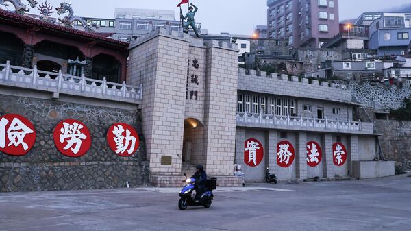 A motorbike passes by a welcome gate of the former port landing area in Dongyin, Taiwan, March 15, 2022.  - Sputnik International