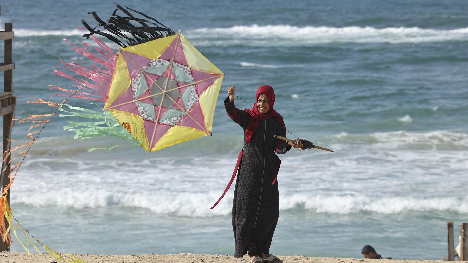 A Palestinian woman flies akite on the beach of Khan Yunis in the southern Gaza Strip, on November 11, 2021 - Sputnik International, 1920, 25.03.2022