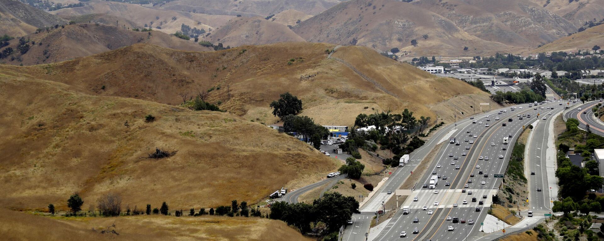 FILE - U.S. Highway 101 passes between two separate open space preserves on conservancy lands in the Santa Monica Mountains in Agoura Hills, Calif., July 25, 2019. Groundbreaking is set for next month on what will be the world's largest wildlife crossing, a bridge over a major Southern California highway that will provide more room to roam for mountain lions and other animals hemmed in by urban sprawl. A ceremony marking the start of construction for the span over U.S. 101 near Los Angeles will take place on Earth Day, April 22, the National Wildlife Federation announced on Thursday, March 24, 2022. - Sputnik International, 1920, 26.03.2022