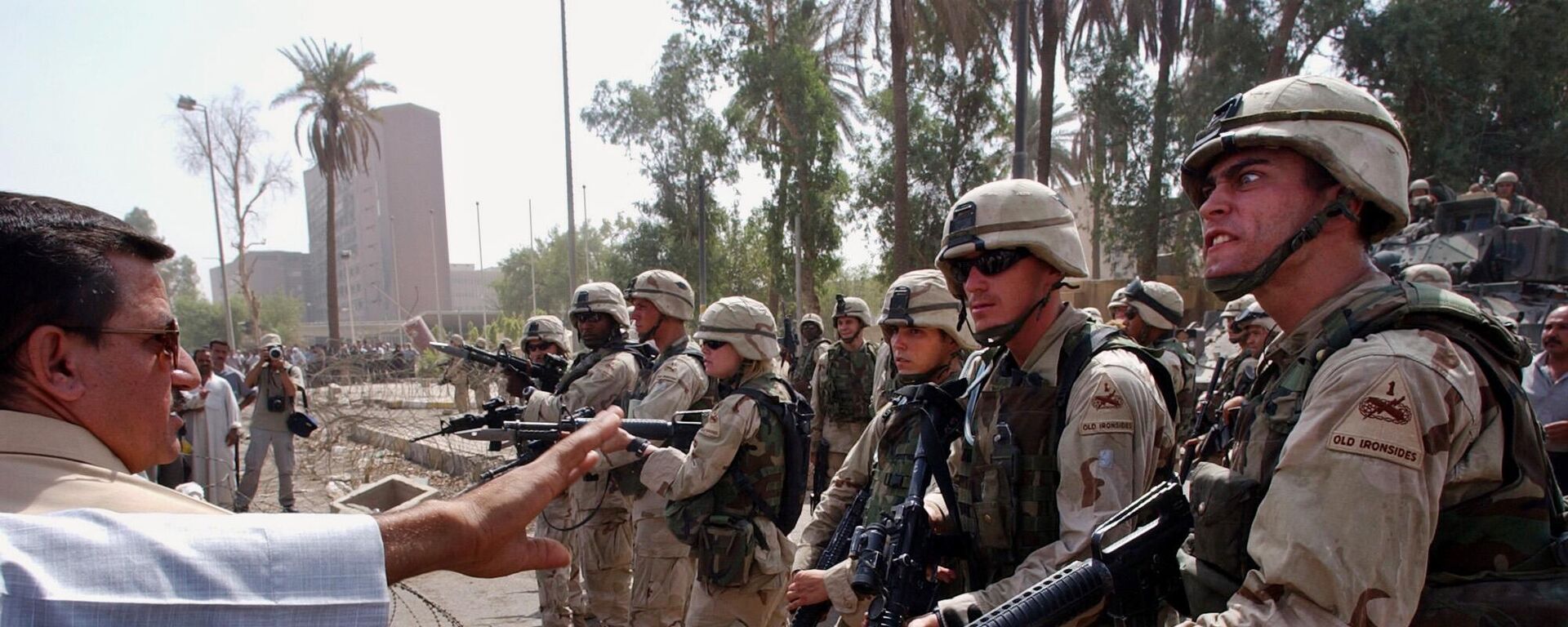  In this June 18, 2003 file photo, U.S. soldiers prevent former Iraqi soldiers from trying to enter the American headquarters during a deadly demonstration in Baghdad, Iraq.  - Sputnik International, 1920, 05.02.2023