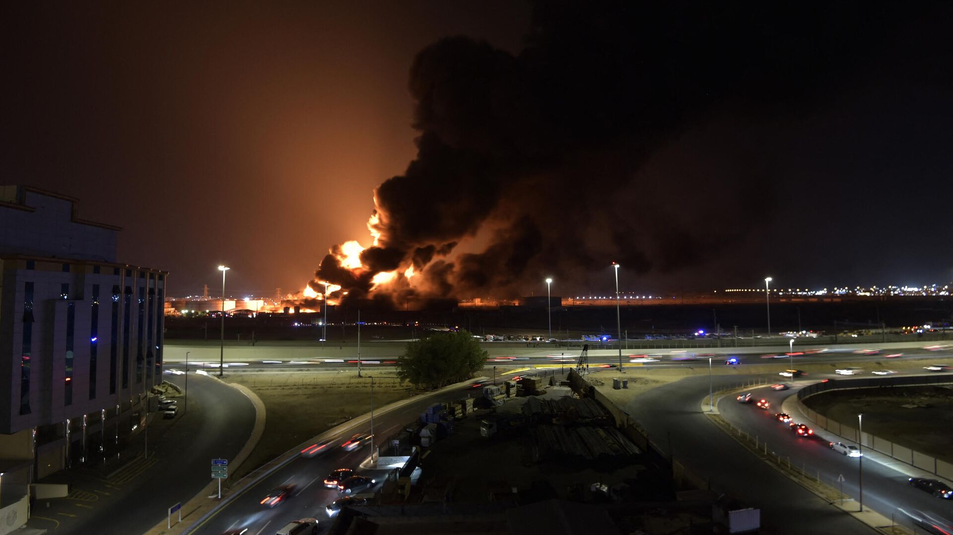 Cars drive on the roads as smoke and flames rise from a Saudi Aramco oil facility in Saudi Arabia's Red Sea coastal city of Jeddah, on March 25, 2022, following a reported Yemeni rebels attack - Sputnik International, 1920, 26.03.2022