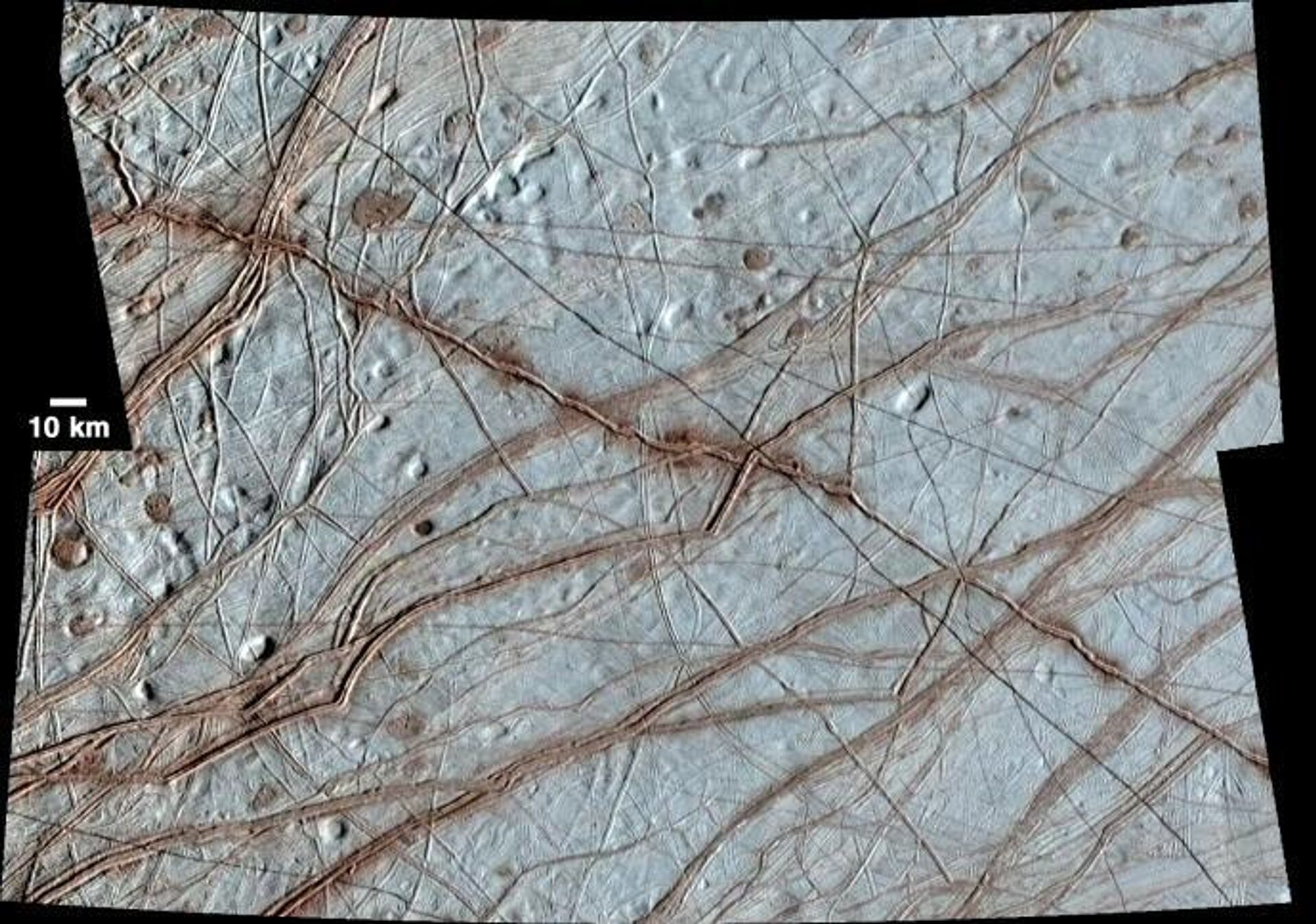 Europa's surface is covered with a vast network of linear features such as cracks, ridges, and bands, as well as other smaller circular features that include pits, spots, domes, and microchaos. This image, created from clear-filter images taken on the Galileo spacecraft's 17th orbit around Jupiter and colorized with lower-resolution images taken on Galileo's first orbit around Jupiter, shows a huge variety of these feature types.  - Sputnik International, 1920, 26.03.2022