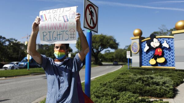 Disney employee Nicholas Maldonado holds a sign while protesting outside of Walt Disney World on March 22, 2022 in Orlando, Florida. - Sputnik International