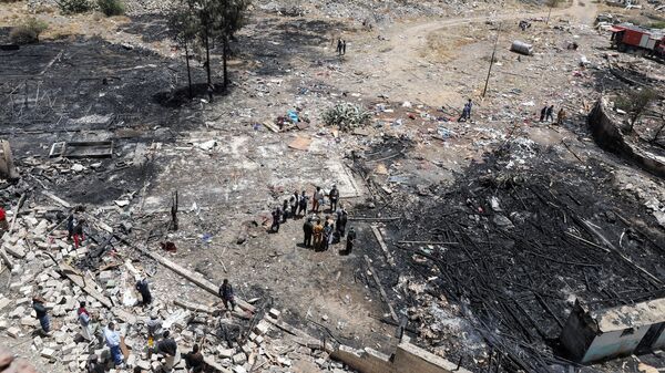 People stand at the site of Saudi-led air strikes in Sanaa, Yemen March 26, 2022. - Sputnik International