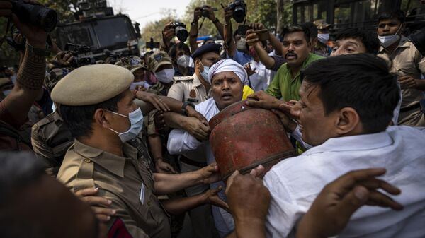 A Delhi police officer tries snatch an empty Liquefied Petroleum Gas (LPG) cylinder from opposition Congress party supporters during a protest against rising inflation and price hike of essential commodities in New Delhi, India, Wednesday, March 23, 2022 - Sputnik International