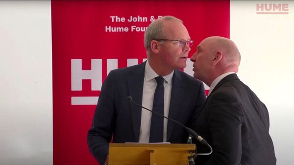 Irish Foreign Minister Simon Coveney learns about a potential security threat during his speech at an event of the The John And Pat Hume Foundation in Belfast - Sputnik International