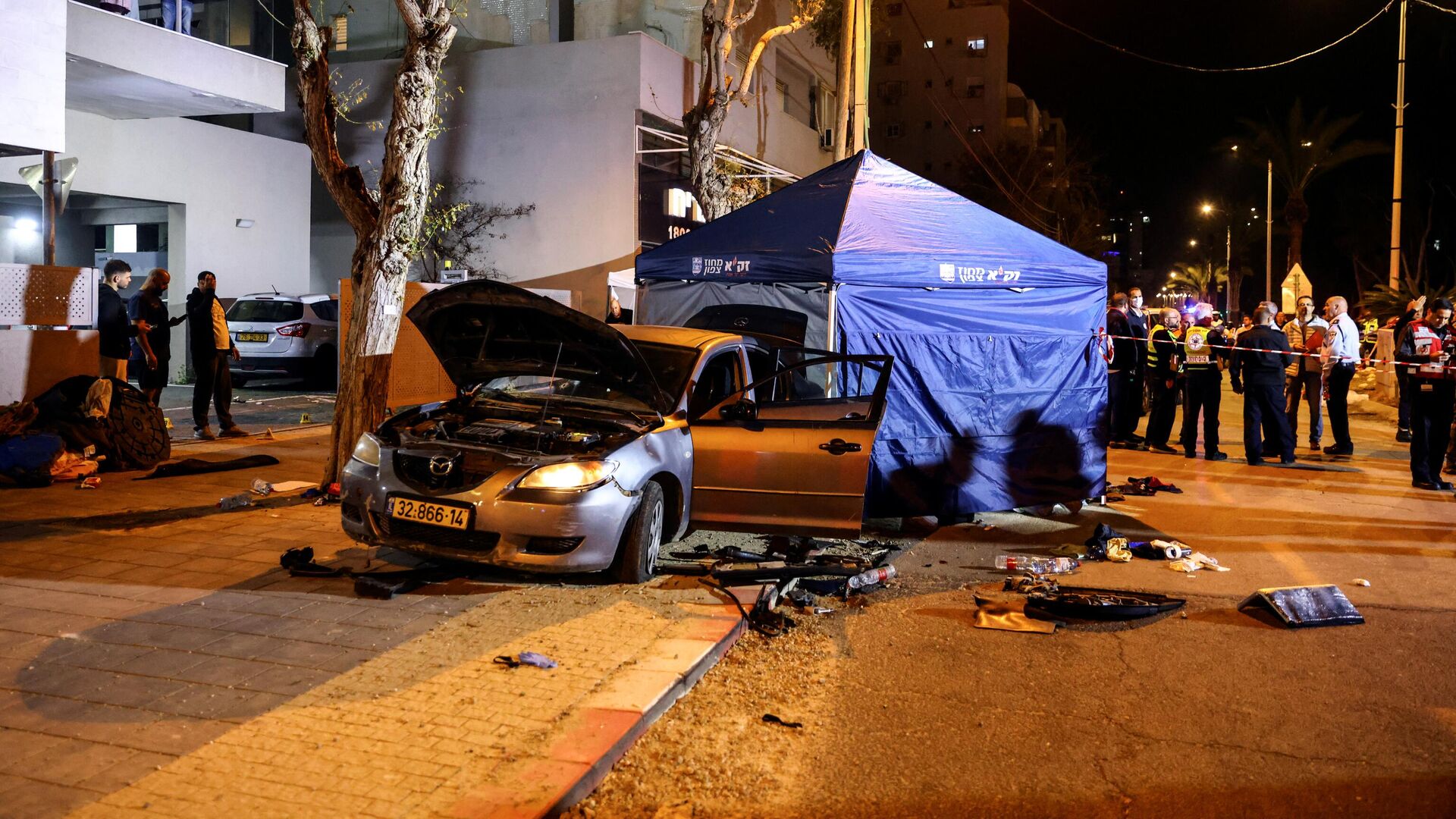The wreckage of gunmens' car is seen following an attack in which people were killed on a main street in Hadera, Israel, March 27, 2022. REUTERS/Ronen Zvulun - Sputnik International, 1920, 28.03.2022