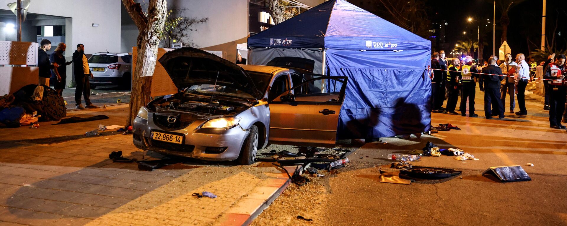 The wreckage of gunmens' car is seen following an attack in which people were killed on a main street in Hadera, Israel, March 27, 2022. REUTERS/Ronen Zvulun - Sputnik International, 1920, 28.03.2022
