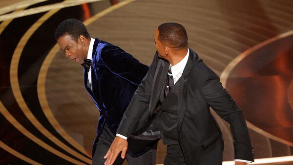 Will Smith (R) hits Chris Rock as Rock spoke on stage during the 94th Academy Awards in Hollywood, Los Angeles, California, U.S., March 27, 2022. - Sputnik International
