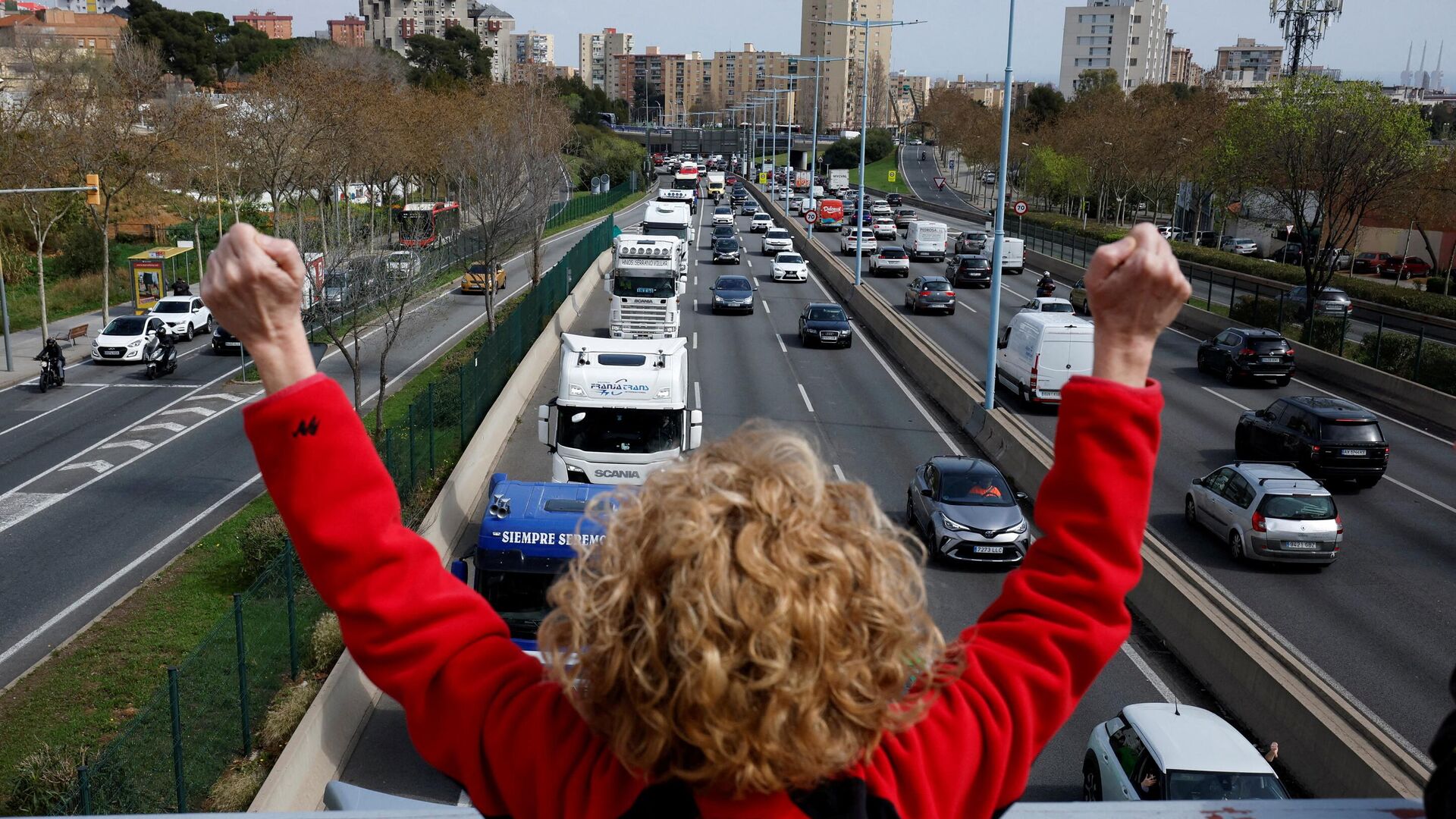A woman shows her support for truck drivers who protest against the rise of fuel prices and against their working conditions with a slow march along the B-20 road, in Barcelona, Spain, March 21, 2022 - Sputnik International, 1920, 29.03.2022