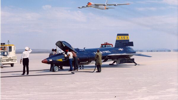 One of three  X-15 rocket planes from North American rests on Rogers Dry Lake, Calif. in September 1961, following a mission. The B-52 launch aircraft flies overhead. - Sputnik International