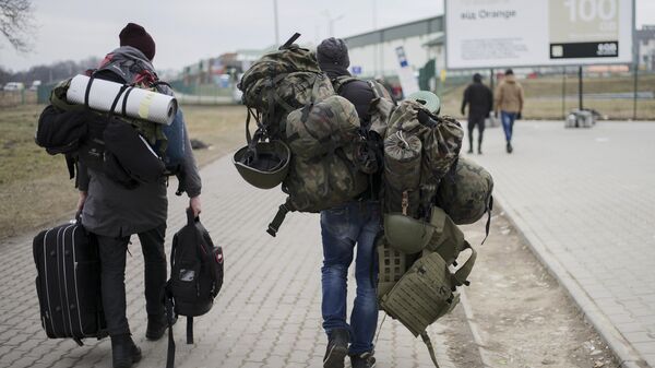 A man carries combat gear as he leaves Poland to fight in Ukraine, at the border crossing in Medyka, Poland, Wednesday, March 2, 2022 - Sputnik International