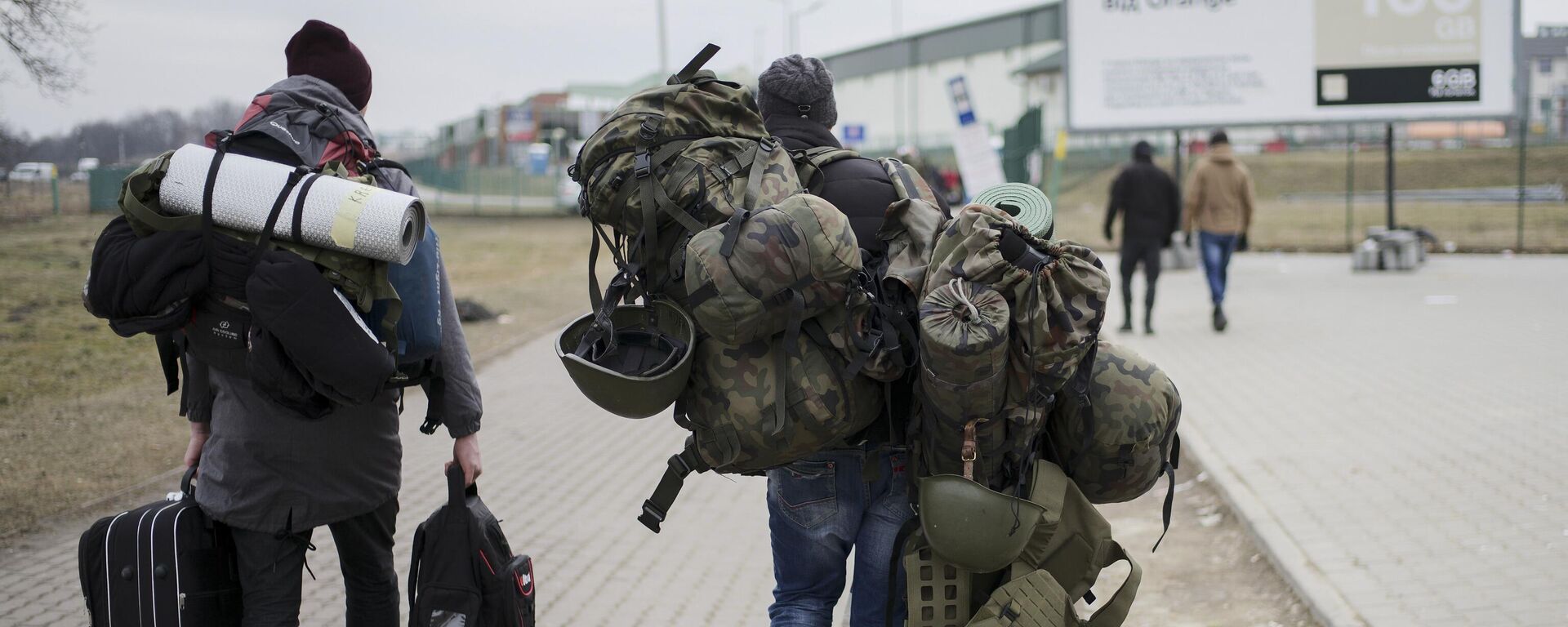 A man carries combat gear as he leaves Poland to fight in Ukraine, at the border crossing in Medyka, Poland, Wednesday, March 2, 2022 - Sputnik International, 1920, 08.06.2022